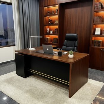 "A classic walnut wood executive desk with a matte black front modesty panel and horizontal gold accent bars."