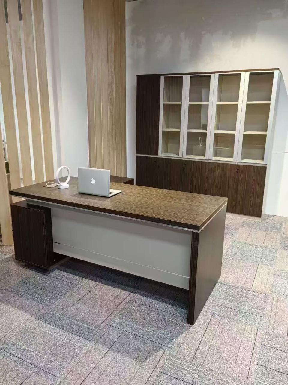 "A contemporary dark brown wood executive desk featuring a contrasting light grey front modesty panel and a compact side pedestal cabinet."