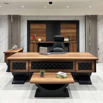 "A luxurious walnut wood executive desk featuring tufted black leather accents on the front modesty panel and heavy, curved black pedestal bases."