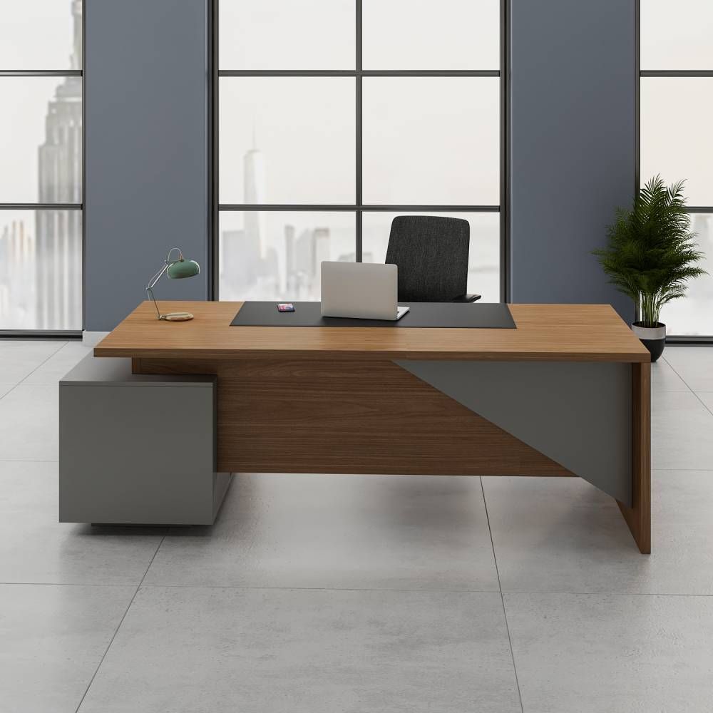 "A contemporary rectangular executive desk in a warm teak wood finish, featuring a geometric grey accent on the front modesty panel and a low side storage pedestal."