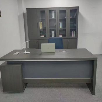 "A contemporary grey-brown wood executive desk with a blue-grey front modesty panel and a compact side pedestal cabinet."