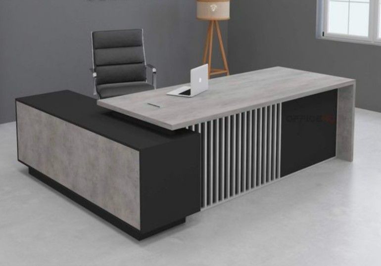 "A modern L-shaped executive desk in light grey wood and matte black, featuring a slatted vertical-line modesty panel and a low-profile side return."