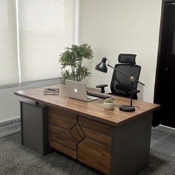 "A contemporary wooden manager desk in a walnut finish with a dark grey outer frame, featuring a geometric diamond pattern panel on the front."