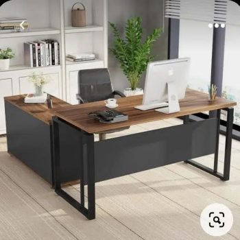 "An L-shaped manager desk with a dark walnut wood grain desktop, a matte charcoal black metal loop frame, and an attached charcoal black side storage return cabinet."