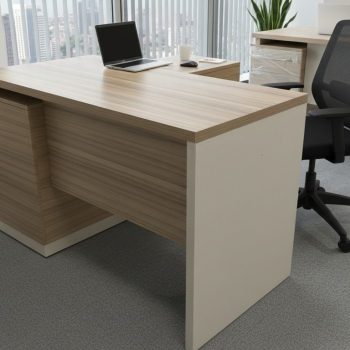 "A contemporary two-tone executive or manager desk featuring a rich teak wood laminate desktop and front panel, set within a matte beige frame structure. A small side return extends to the back-right."