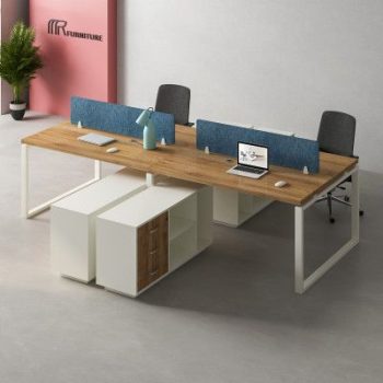 "A 4-person back-to-back modular office workstation desk featuring natural wood-grain tabletops, white steel O-shaped loop legs, a pair of blue fabric privacy divider screens, and low-slung white under-desk storage returns."