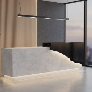 "A contemporary two-tone reception desk combining a smooth grey concrete-look block with a black marble section, separated by a dramatic, jagged fault-line crack embedded with warm LED under-lighting."