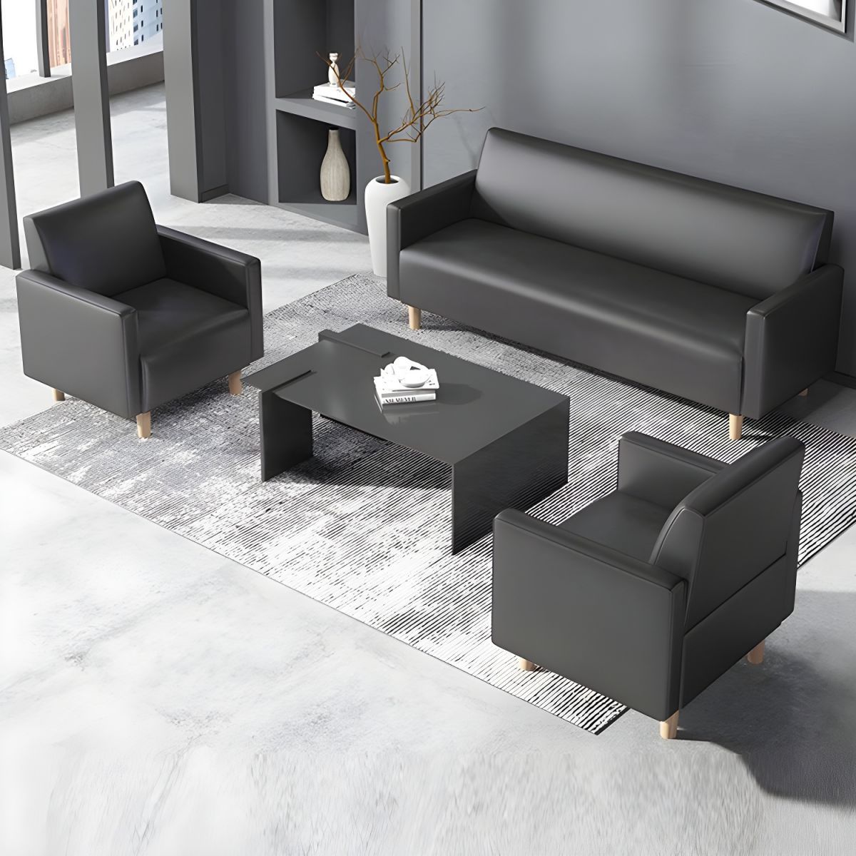 "A modern three-piece sofa set consisting of a sleek black matte three-seater couch and two matching single armchairs, all featuring plain cushions and light-colored wooden legs."